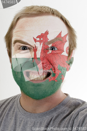 Image of Face of crazy angry man painted in colors of wales flag