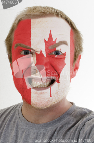 Image of Face of crazy angry man painted in colors of canada flag