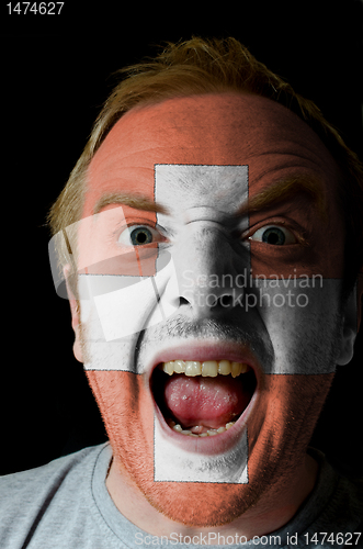 Image of Face of crazy angry man painted in colors of swiss flag