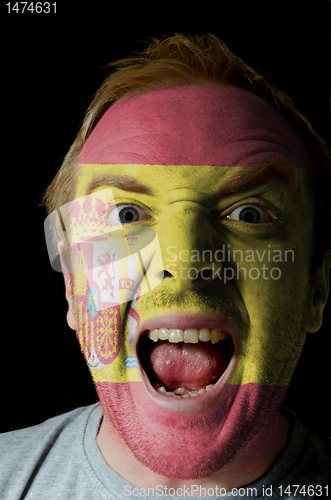 Image of Face of crazy angry man painted in colors of spain flag