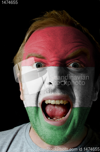 Image of Face of crazy angry man painted in colors of hungary flag