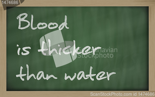 Image of " Blood is thicker than water " written on a blackboard