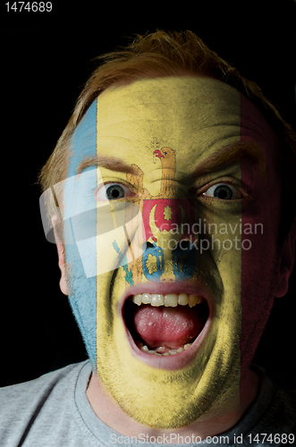 Image of Face of crazy angry man painted in colors of moldova flag