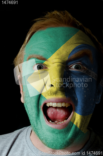 Image of Face of crazy angry man painted in colors of Brazil flag