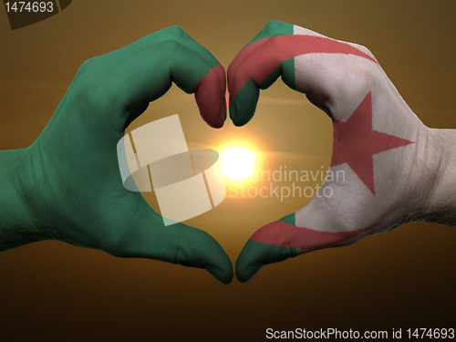 Image of Heart and love gesture by hands colored in algeria flag during b