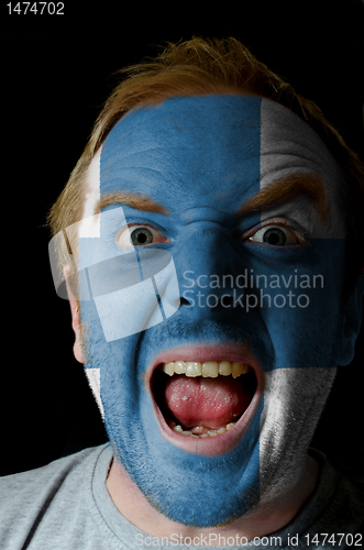 Image of Face of crazy angry man painted in colors of finland flag