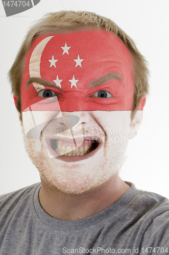 Image of Face of crazy angry man painted in colors of singapore flag