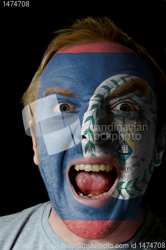 Image of Face of crazy angry man painted in colors of Belize flag