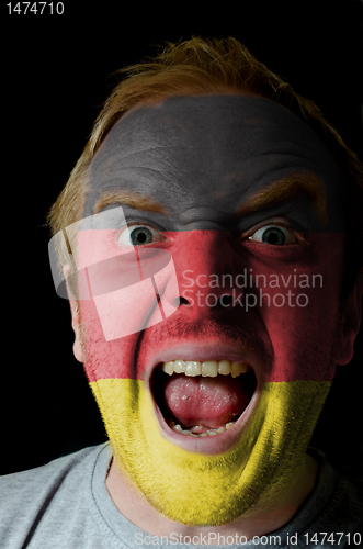Image of Face of crazy angry man painted in colors of germany flag