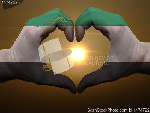 Image of Heart and love gesture by hands colored in afghanistan flag duri