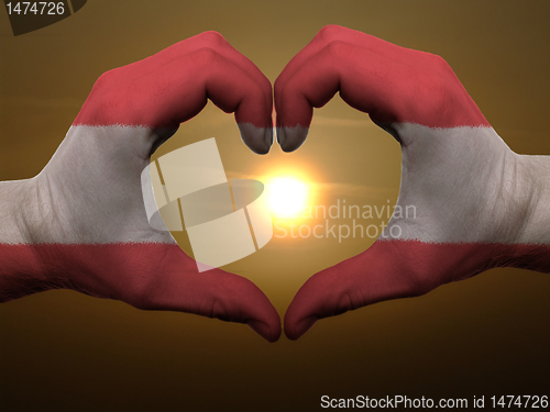 Image of Heart and love gesture by hands colored in austria flag during b