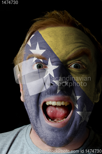 Image of Face of crazy angry man painted in colors of Bosnia and Herzegov