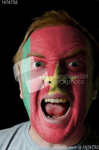 Image of Face of crazy angry man painted in colors of Cameroon flag