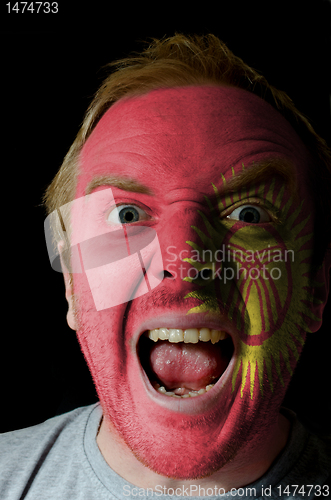 Image of Face of crazy angry man painted in colors of kyrghyzstan flag