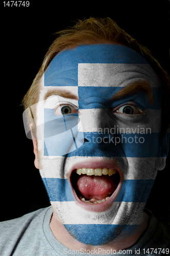 Image of Face of crazy angry man painted in colors of greece flag