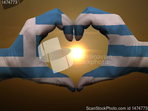 Image of Heart and love gesture by hands colored in greece flag during be