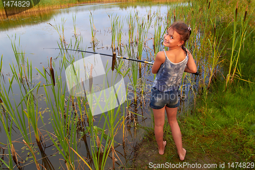 Image of pretty young girl fishing on river in summer