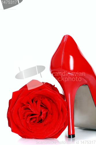Image of Red female shoes with high heels and a flower.