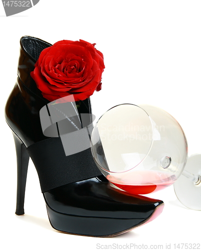 Image of Glass, beautiful boots and a rose on a white background.