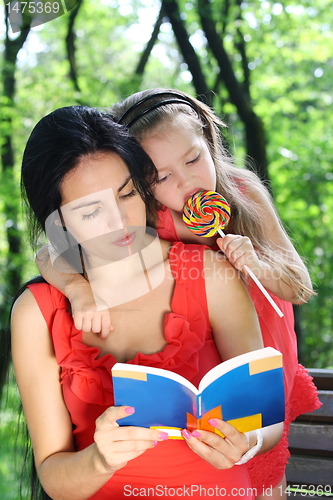 Image of  Little girl and mother reading the book. 