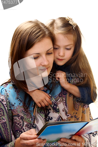 Image of Young woman reads a book a little girl.