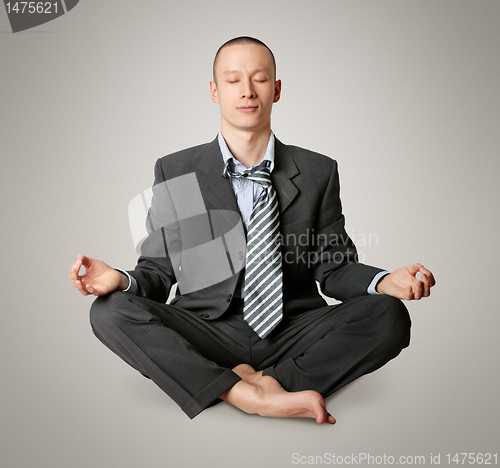 Image of businessman in lotus pose meditating