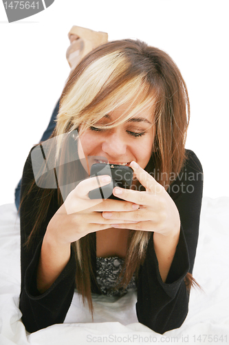 Image of Teenage girl chatting with cell phone lying down  - isolate 