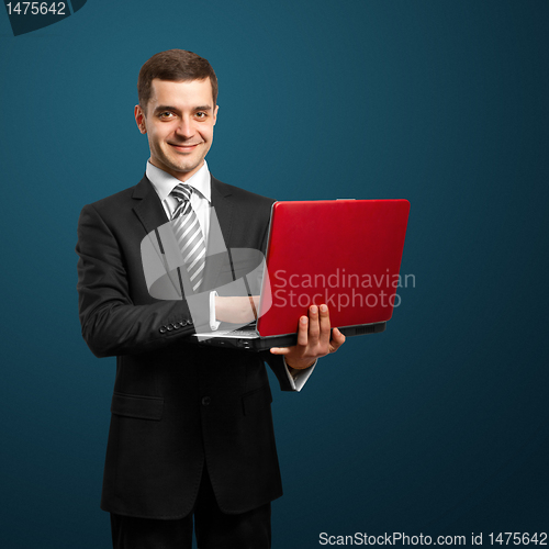 Image of male in suit with laptop in his hands