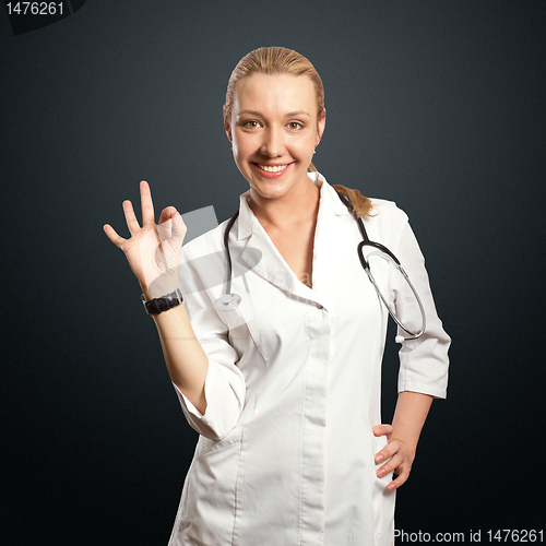 Image of young doctor woman shows ok