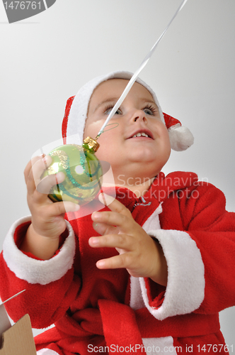 Image of Santa baby playing with a Christmas ball