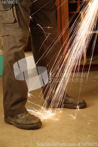 Image of Worker with angle grinder only feet