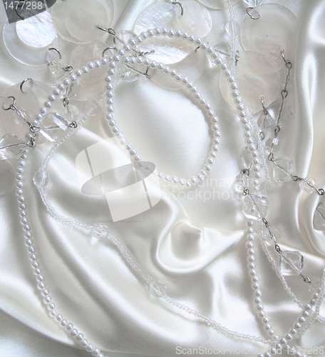 Image of White pearls and nacreous beeds on white silk as wedding backgro