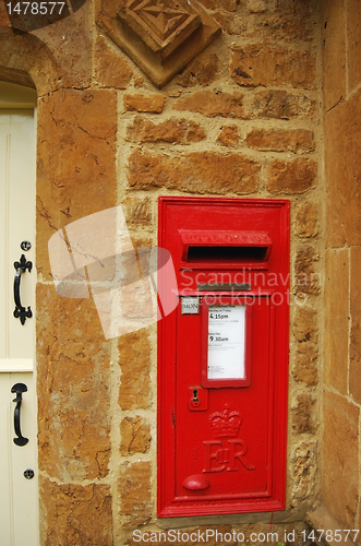 Image of Red british post box on stone wall