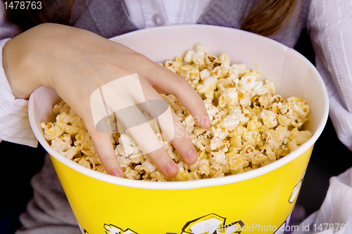 Image of hand in a bucket of popcorn