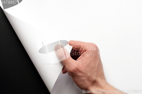 Image of hand turning paper