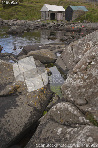 Image of Boat houses with rocks in the foreground