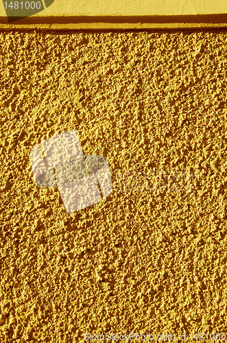 Image of Yellow painted textured wall closeup.