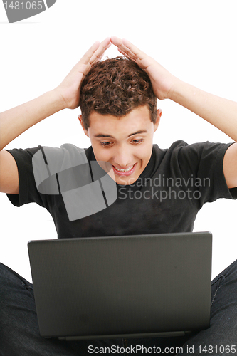 Image of young man shocked with something he see on his laptop computer 
