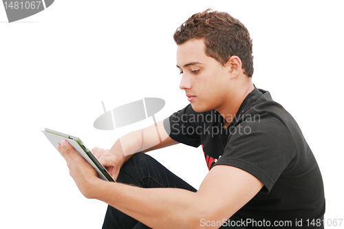 Image of School boy with electronic tablet sitting in the floor