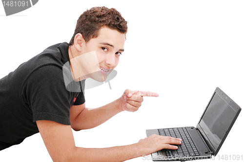 Image of Young student is lying on the floor and looks  his laptop. Isola