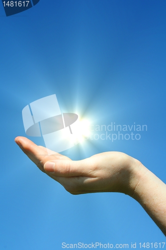 Image of hand sun and blue sky