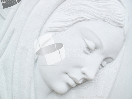 Image of virgin mary on white marble tombstone
