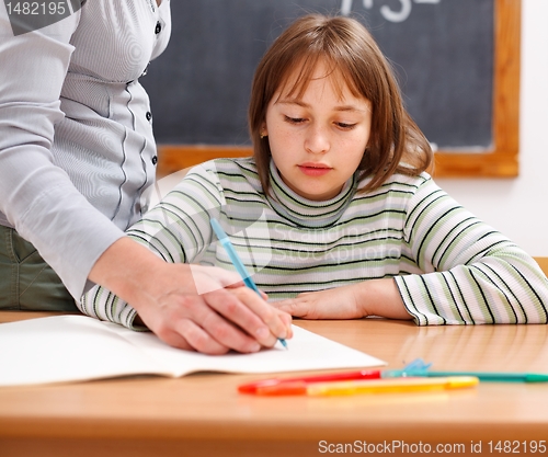 Image of Teacher showing writing to schoolgirl