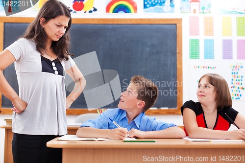 Image of Angry teacher looking at scared boy