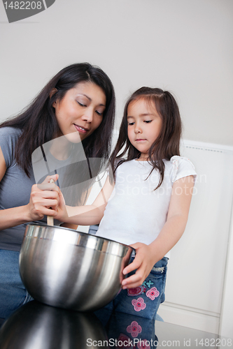 Image of Mother and daughter in kitchen baking