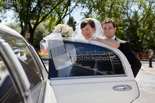 Image of Bridge and Groom entering Limo