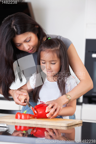 Image of Mother teaches daughter to cook