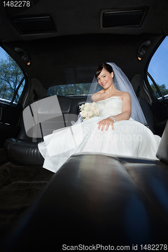 Image of Bride With Flower Bouquet in Limo
