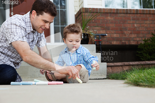 Image of Father Drawing With Chalk on Ground