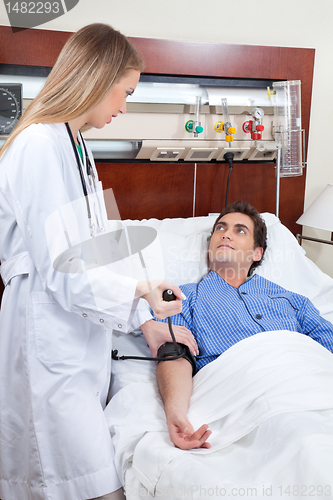 Image of Doctor checking the blood pressure of patient